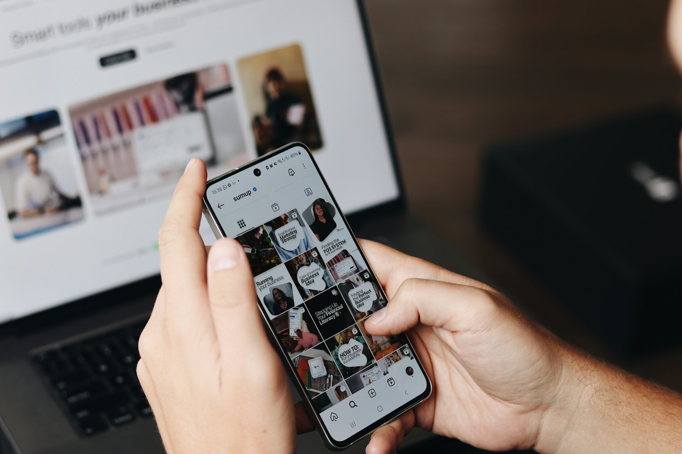 A hand scrolling through a social feed on a phone